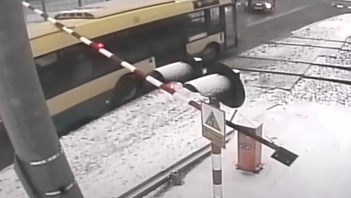 Vérfagyasztó jelenet a vasúti átjáróban - a lehajtott sorompó alá szorult egy busz! (Videó)